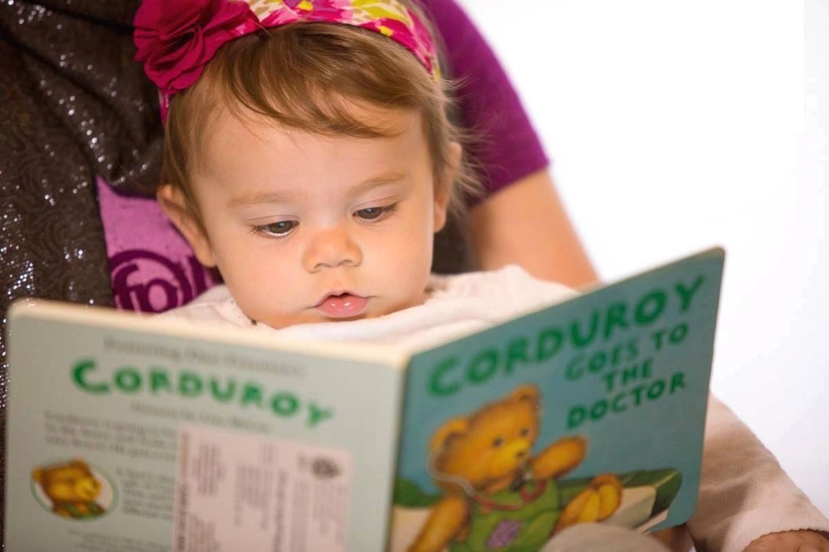 A baby holding an open picture book